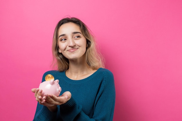 Meisje zet fysieke spaarpot in het spaarvarken