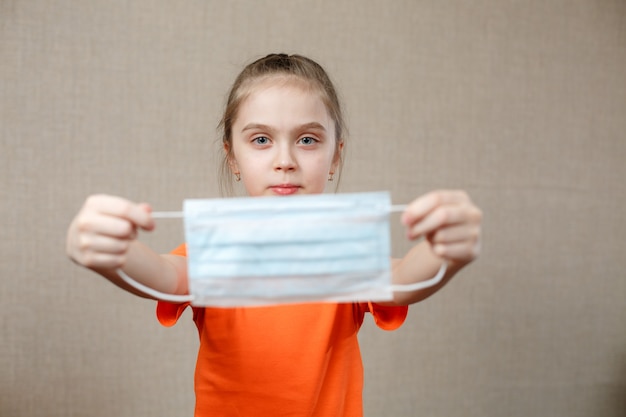 Meisje zet medisch gezichtsmasker op tegen bacteriën en virussen. Selectieve aandacht.