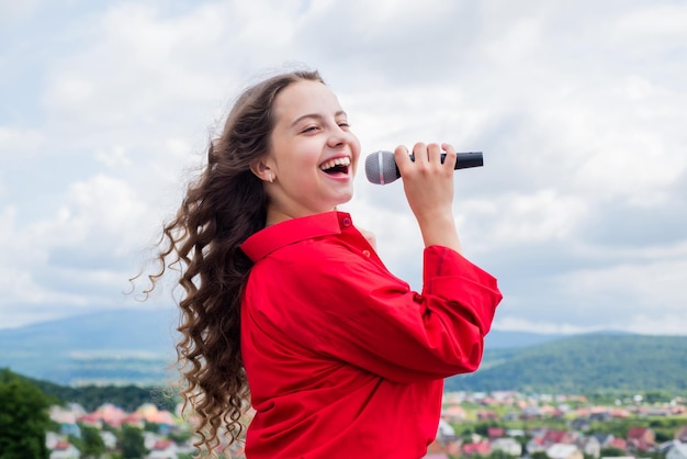 Meisje zingt vocaal schoolconcept karaoke clubmuziek is mijn leven kind zing met microfoon vrolijk evenementmanager kind veel plezier op feest gelukkige zanger met microfoon klassiek cool