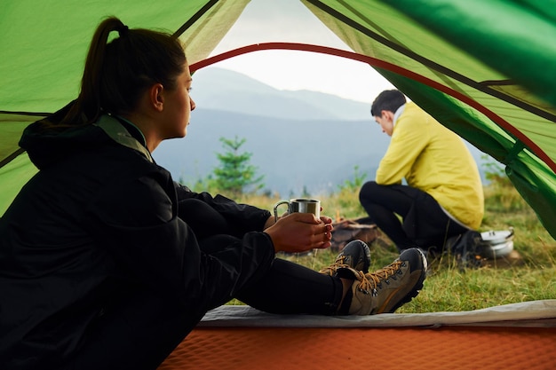 Meisje zit in de tent en kijkt naar vriendje Majestueuze Karpaten Prachtig landschap van ongerepte natuur