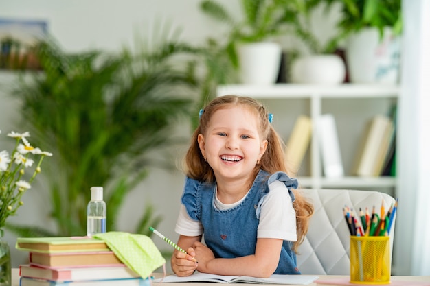 Meisje, zittend aan een tafel met een leerboek