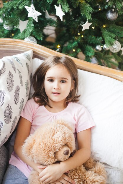 Meisje zittend op de bank thuis op Kerstmis