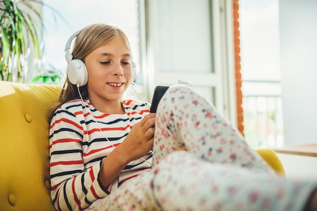 Meisje, zittend op een bank en het gebruik van slimme telefoon