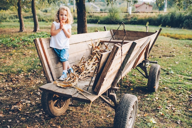 meisje zittend op een oude houten wagen in het dorp