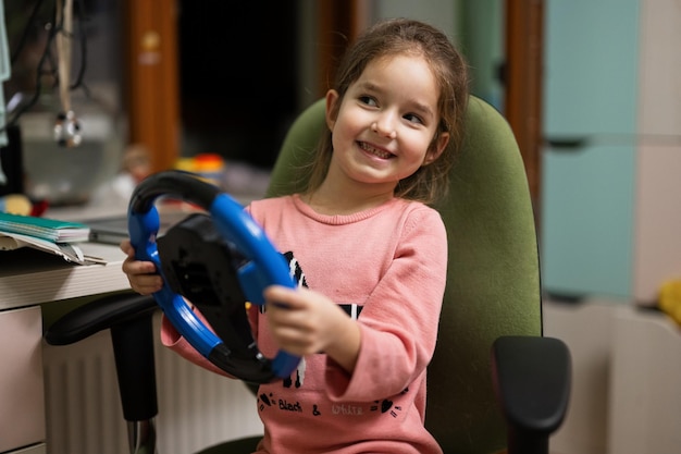 Meisje zittend op een stoel met het stuur van een kind in haar handen in de kinderkamer