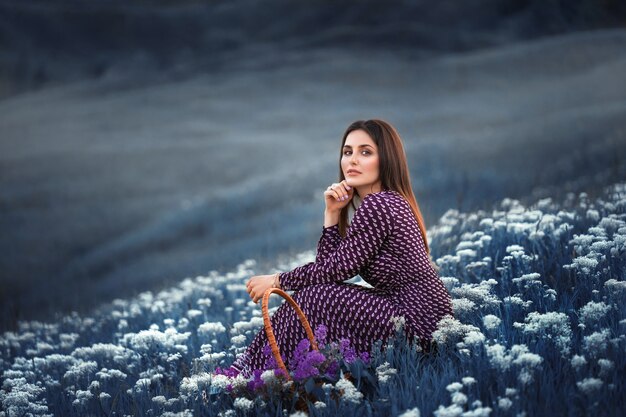 Meisje zittend op een veld met bloeiende witte bloemen