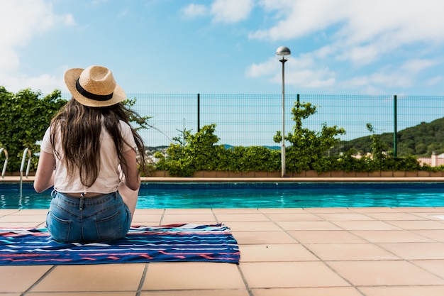 Meisje zonnebaden bij het zwembad in haar huis