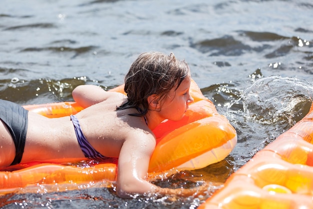 Meisje zwemt met opblaasbaar matras