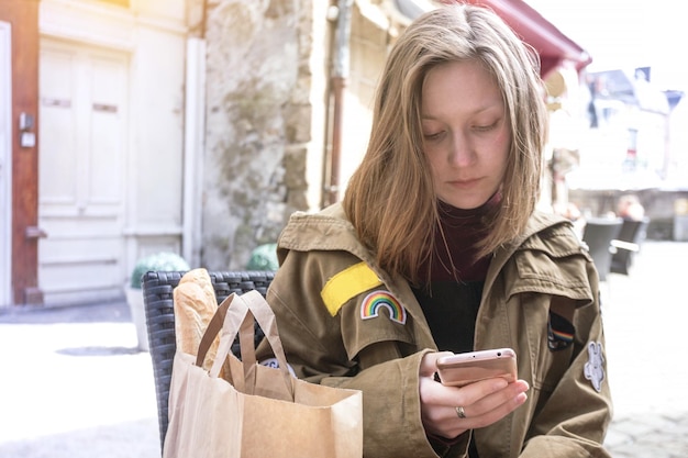 Meisjereiziger zit in een café met een smartphone