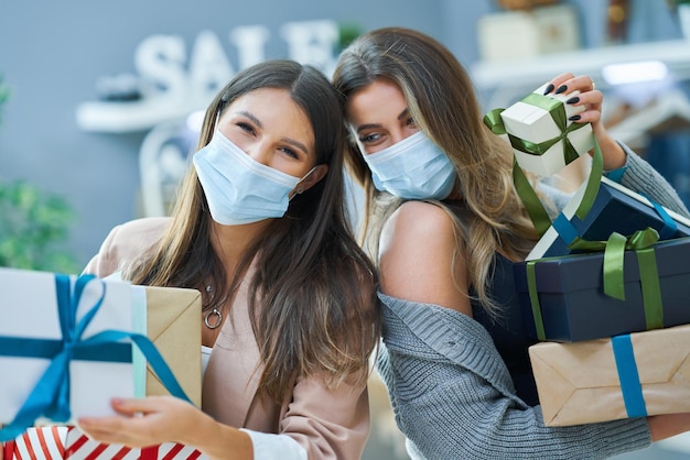 Meisjes bij het winkelen in de winkel met kleding die maskers draagt. Hoge kwaliteit foto