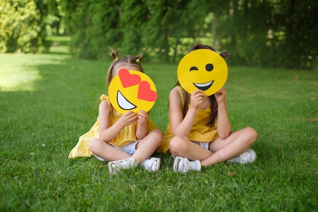 Meisjes die gezichten-emoticons bedekken met harten in plaats van ogen