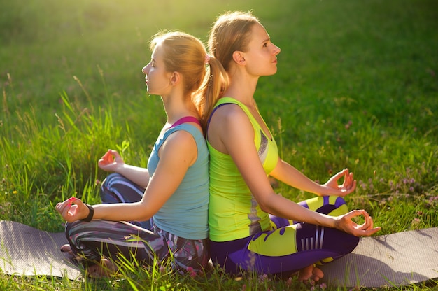 Meisjes die yoga buiten in het bos in de ochtend stellen