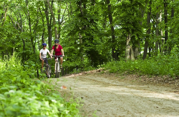 Meisjes fietsen in het bos