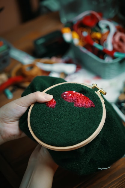 Foto meisjes handen borduurwerk paddenstoel hoed op frame vrouw naaien op groene doek concept van hobby's