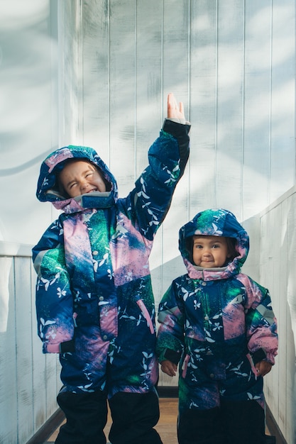 Meisjes in dezelfde warme overall. winterkleding voor kinderen van alle leeftijden