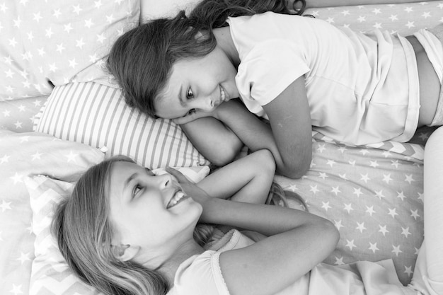 Meisjes kinderen lagen op bed met schattige kussens bovenaanzicht Pyjama party concept Meisjes hebben plezier Meisjesachtige geheimen eerlijk en oprecht Vrienden vertrouwen en voelen zich op hun gemak Beste vrienden voor altijd