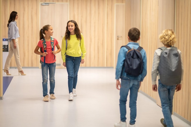 Meisjes lopen door gang en jongens met rug naar camera