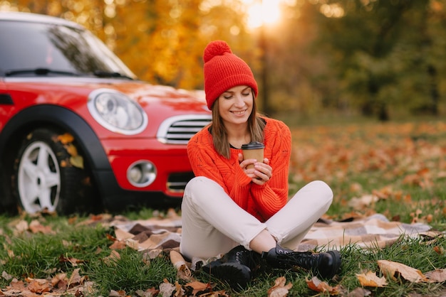 Meisjes lopen in herfstpark in rode auto herfststemming concept