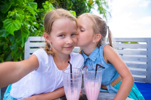 Meisjes nemen selfie en smakelijke cocktails drinken in tropische resort