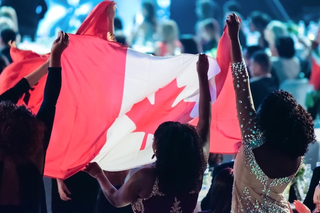 Meisjes op een internationaal evenement juichen hun land toe en hijsen de vlag van canada