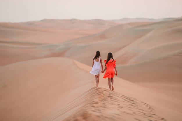 Meisjes tussen de duinen in de Rub al-Khali-woestijn in de Verenigde Arabische Emiraten