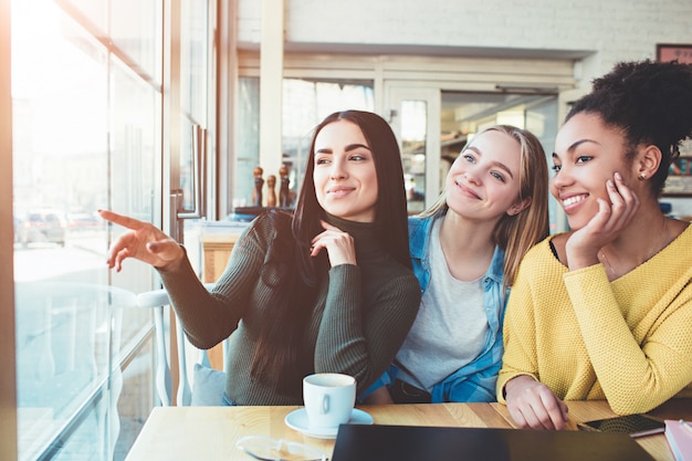 Meisjes zitten aan de tafel in café