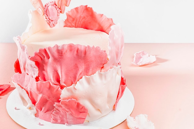 Meisjesachtige verjaardagstaart Roze dessert met mastiekbladeren in de vorm Taart voor vrouwenMensen die activiteiten doen