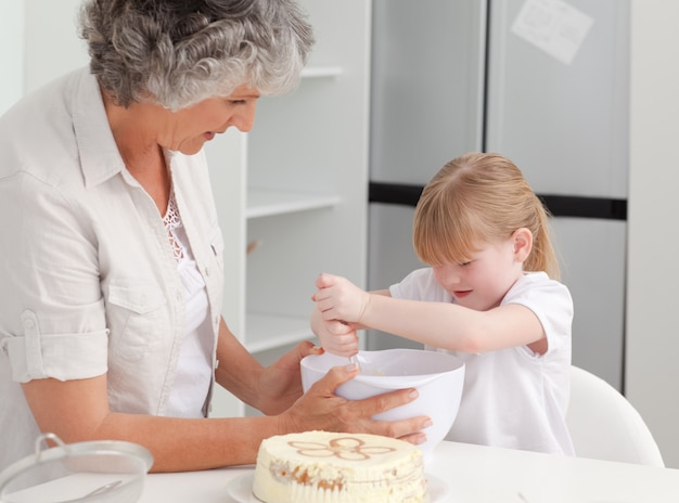 Meisjesbaksel met haar grootmoeder thuis