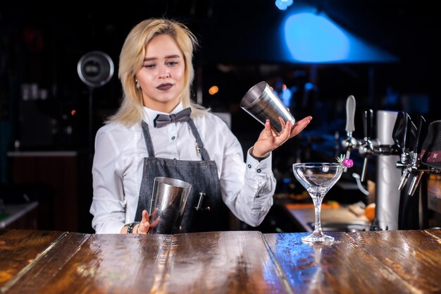 Meisjesbarman formuleert een cocktail in het café