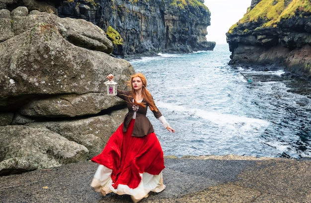 Foto meisjescosplayer met aansteker in de kloofhaven van gjogv faroe island