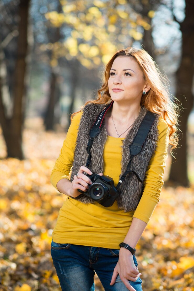 Meisjesfotograaf met een camera maakt een fotoshoot in het herfstpark