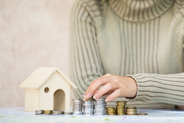 Meisjeshand die de stapel van het geldmuntstuk zaken Financiën en het Bankwezen voor Huis zetten en geld besparen