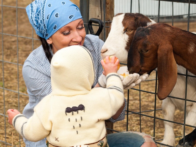 Meisjespeuter met haar moeder op de boerderij.