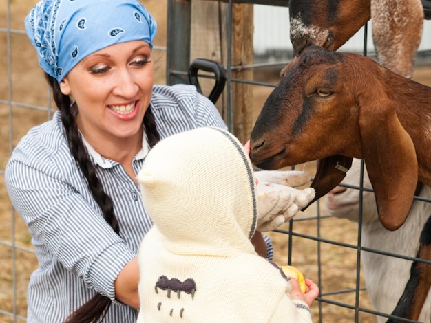 Meisjespeuter met haar moeder op de boerderij.