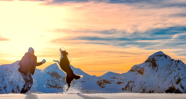 Meisjesspelen met border collie in de sneeuw