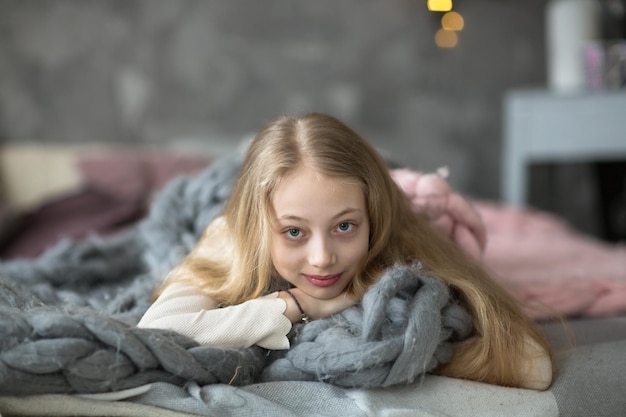 Foto meisjestiener met lang blond haar in echte ruimte