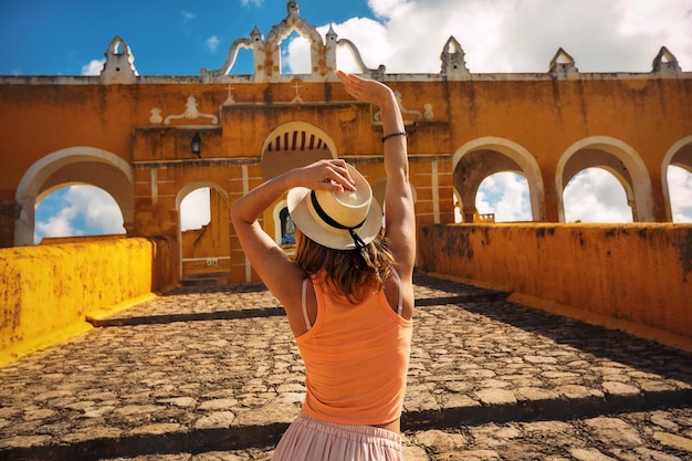 Meisjestoerist in een hoed in de gele Mexicaanse stad Izamal, Mexico