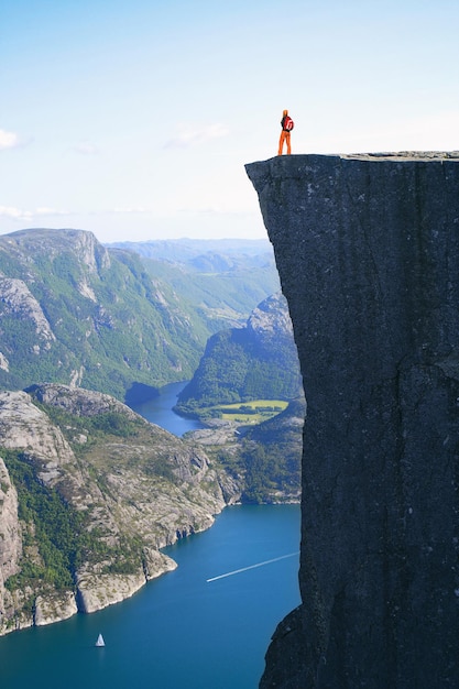 Meisjeswandelaar die op Preikestolen staat en naar de bergen kijkt, Preikestolen - beroemde klif aan de noorse bergen