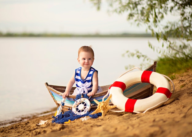 Meisjeszitting in een boot op een zandig strand dichtbij de rivier