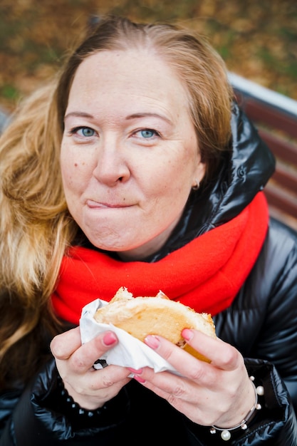 Meisjevrouw die grote hamburger eetcheeseburgerOngezonde voedingWeekend ontspannenBody positiveProblemen met overgewicht