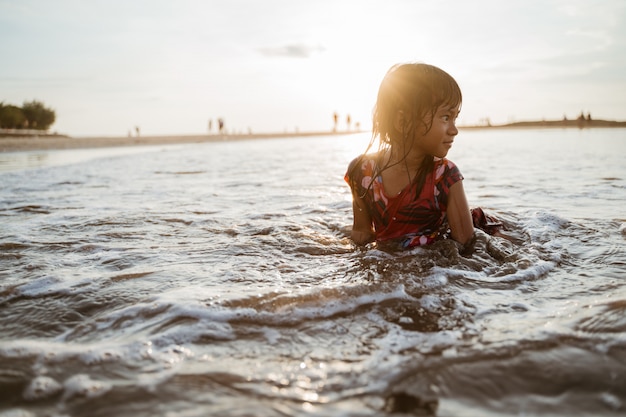 Meisjezitting op zand in het strand