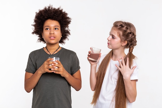 Melk en cacao. Communicatieve jongedame die een interessant verhaal vertelt aan haar vriend terwijl ze een glas cacao draagt