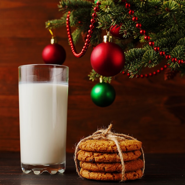 Melk en koekjes voor de kerstman onder de kerstboom. , copyspace.