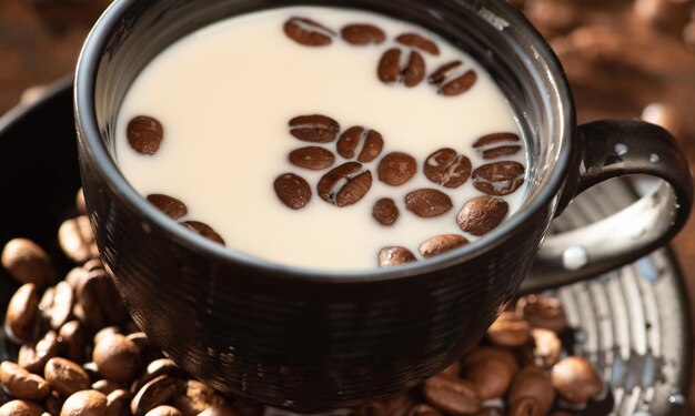 Melk en koffiebonen een zwarte kop met melk en koffiebonen op rustiek hout donkere voedselstijl foto selectieve focus