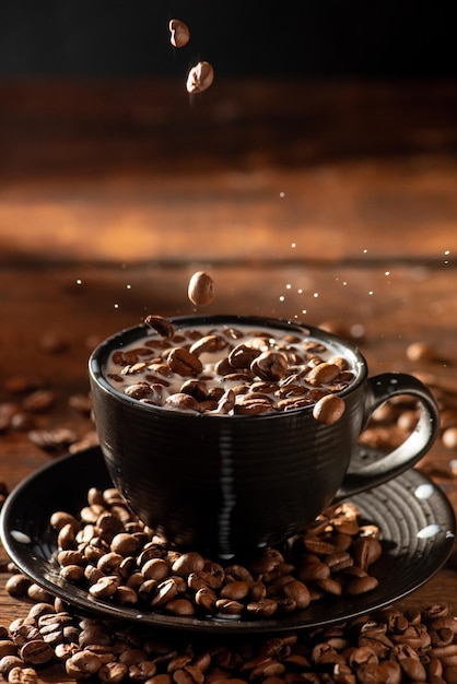 Melk en koffiebonen gieten koffiebonen in een zwarte kop melk op rustiek hout donkere voedselstijl foto selectieve focus