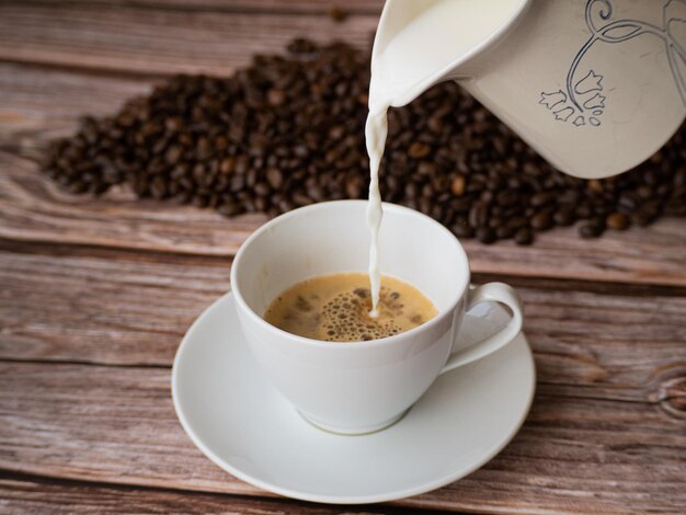 Foto melk in een witte kop koffie gieten