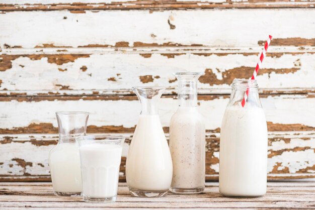 Foto melk in flessen en glas op tafel