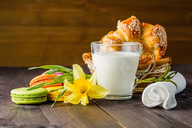 Melk met gebak en lente gele bloem op tafel