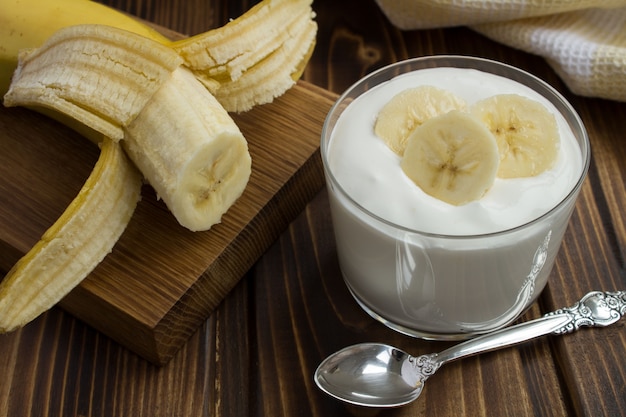 Melk yoghurt met banaan op de houten tafel