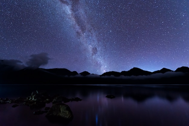 Foto melkweg landschap. duidelijk melkweg boven het meer segara anak in de krater van de berg rinjani aan de nachtelijke hemel. het eiland van lombok, indonesië.